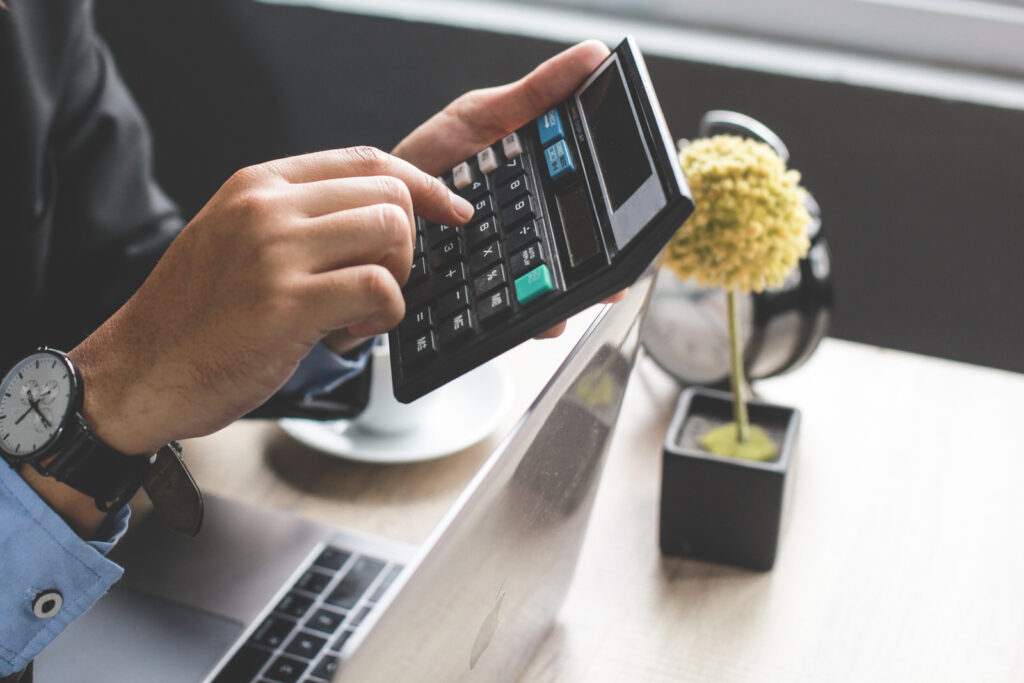 Accountant sitting at his desk using calculator